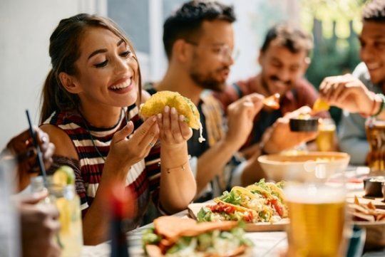 Eine Freundesgruppe isst zusammen Tacos