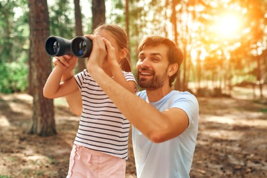 Kind und Vater entdecken Natur im Wald