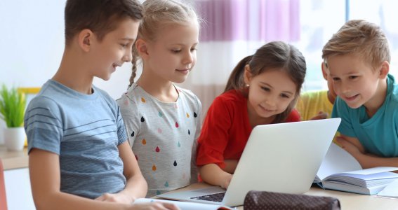 Kinder sitzen vor Laptop