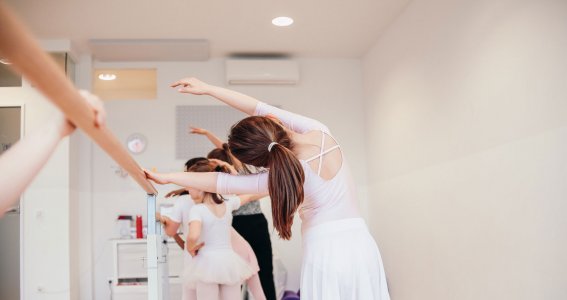 Tänzerinnen machen Übungen an der Ballettstange
