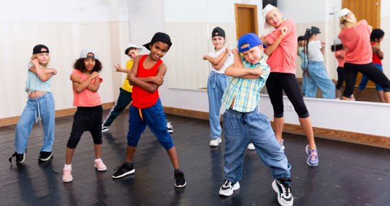 Kinder posieren in Hip Hop Tanzpose in einem Raum mit Spiegelwand