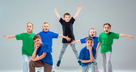 Eine Tanzgruppe posiert in Formation mit blauen und grünen Tshirts