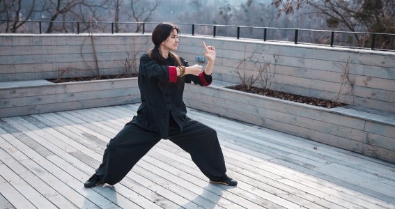 Eine Frau trainiert auf der Dachterrasse vor einem Computer Kung Fu