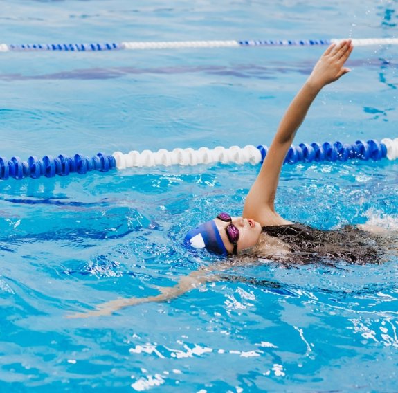 Ein junges Mädchen schwimmt eine Bahn