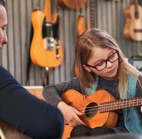 Vater spielt mit seiner Tochter Gitarre