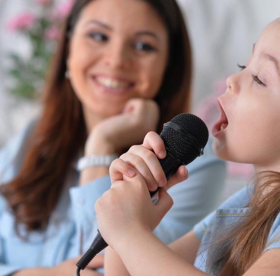 Mutter und Tochter singen mit Mikrofon